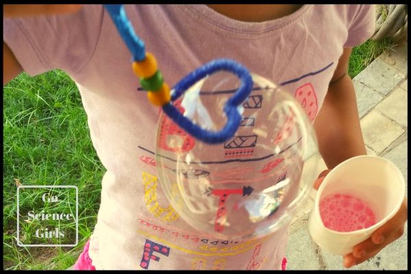 Blowing bubbles with a homemade heart bubble wand