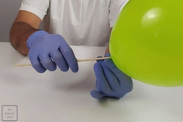 With rotation motion, insert the skewer inside the balloon